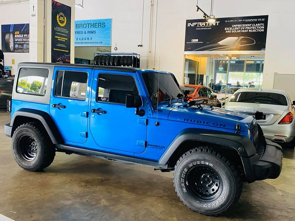 Side view of a blue Jeep Wrangler Rubicon inside Infratint Singapore