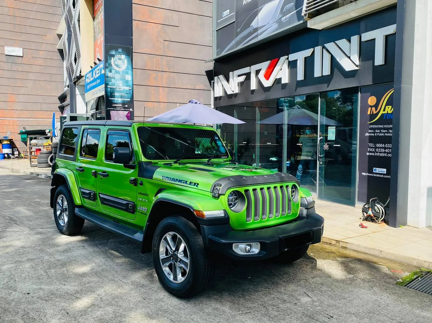 Green Jeep Wrangler parked outside the Infratint Singapore shopfront after window tinting