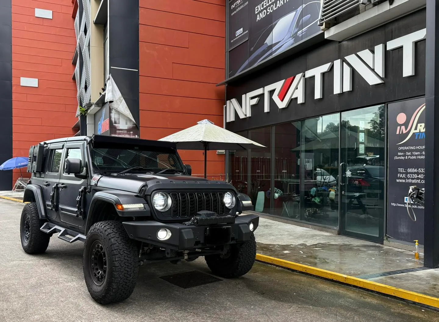 Dark grey lifted Jeep Wrangler front three-quarter view outside Infratint Singapore