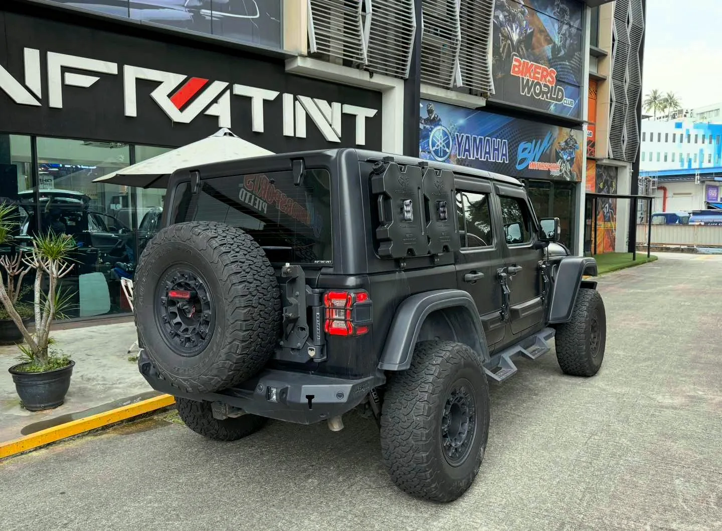 Dark grey Jeep Wrangler rear three-quarter with spare wheel and tinted glass at Infratint Singapore