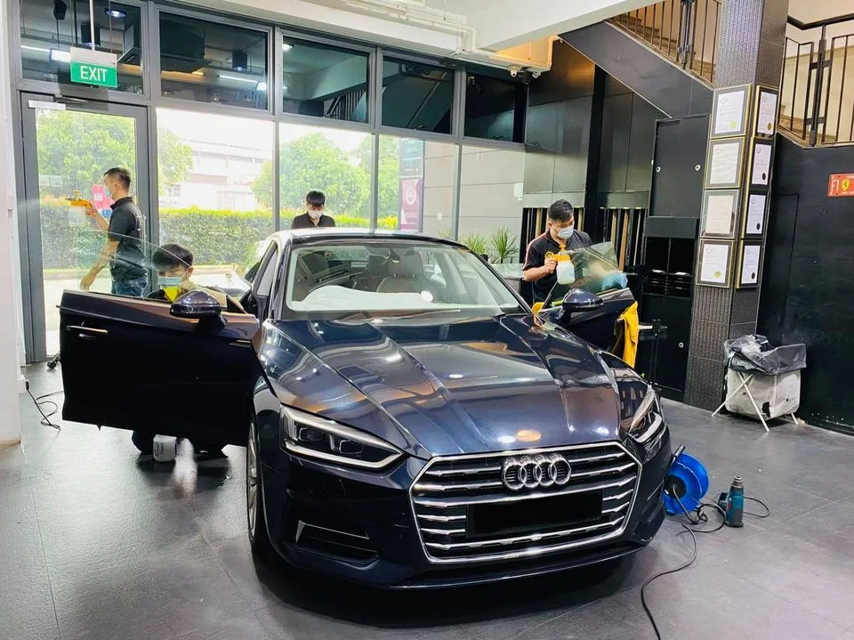 Dark blue Audi sedan front three-quarter during tinting at Infratint Singapore