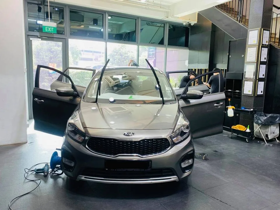 Grey Kia MPV with doors open during window tinting at Infratint Singapore