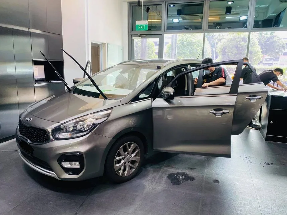 Grey Kia MPV side view during window film install at Infratint Singapore