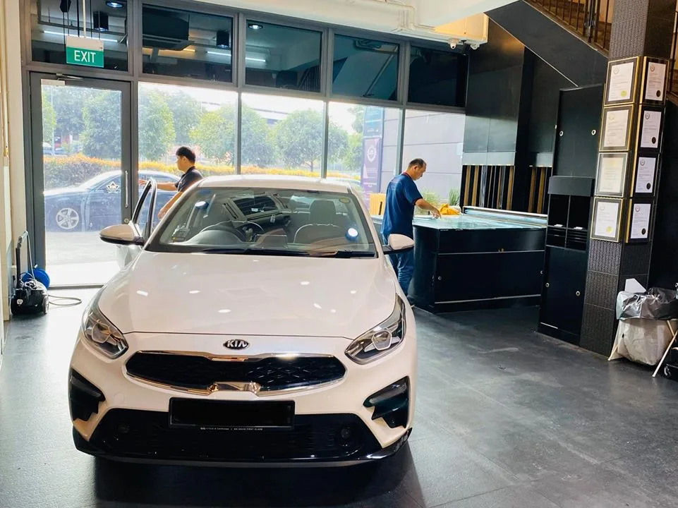 White Kia Cerato sedan front view inside Infratint Singapore for window tinting