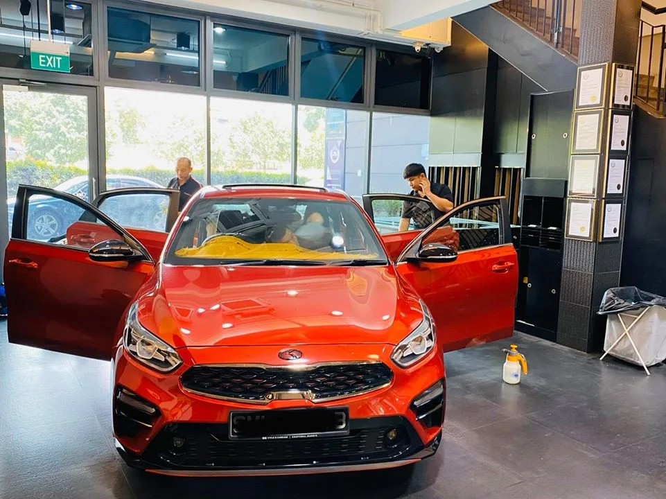 Red Kia Cerato sedan front view with doors open at Infratint Singapore
