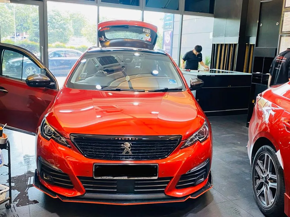 Orange Peugeot estate with tailgate open during window tinting at Infratint Singapore