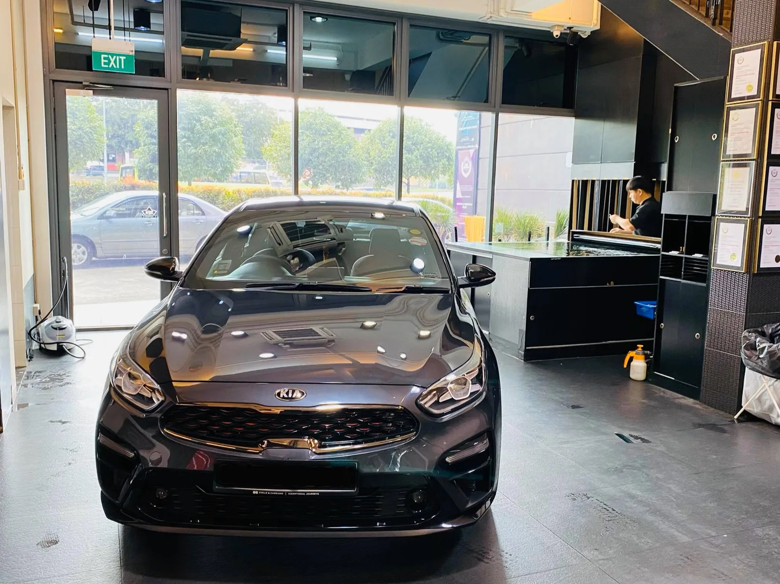 Grey Kia Cerato sedan front view inside the showroom at Infratint Singapore