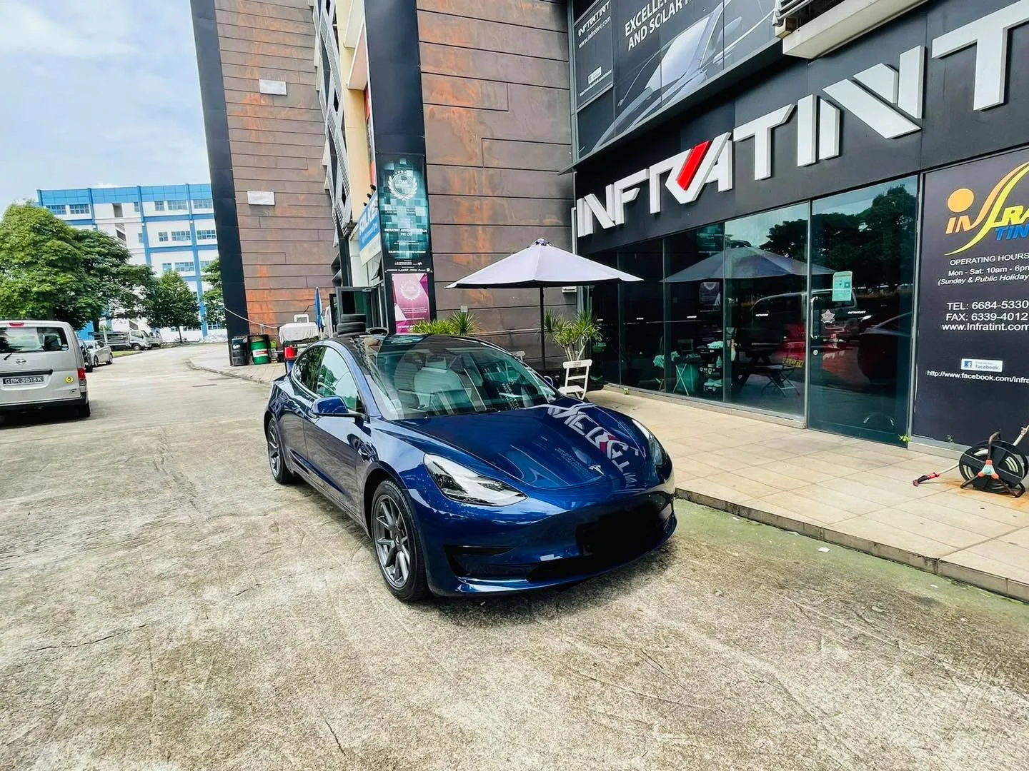 Blue Tesla Model 3 parked outside the Infratint Singapore shopfront