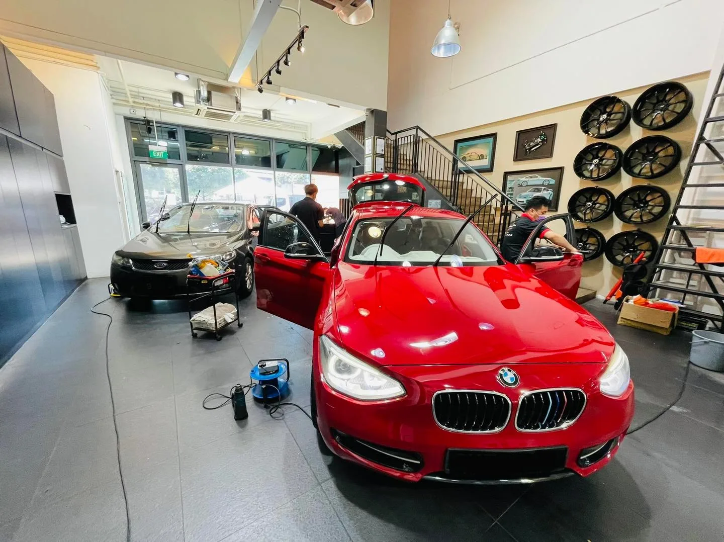 Red BMW 1 Series and grey Subaru being prepped for window tinting at Infratint Singapore