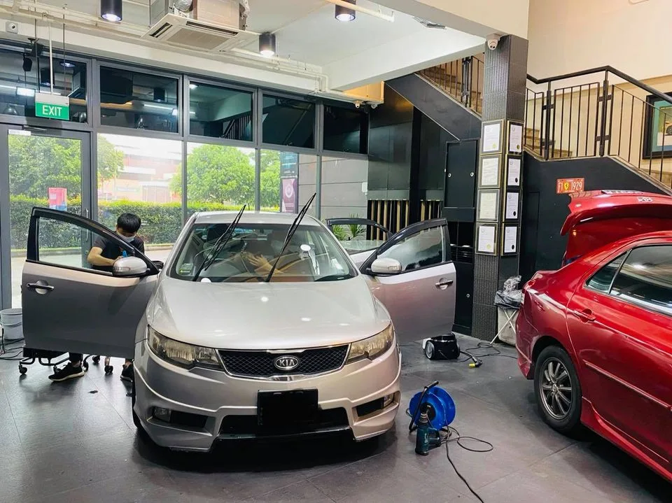 Silver Kia Forte with door open during window tinting at Infratint Singapore