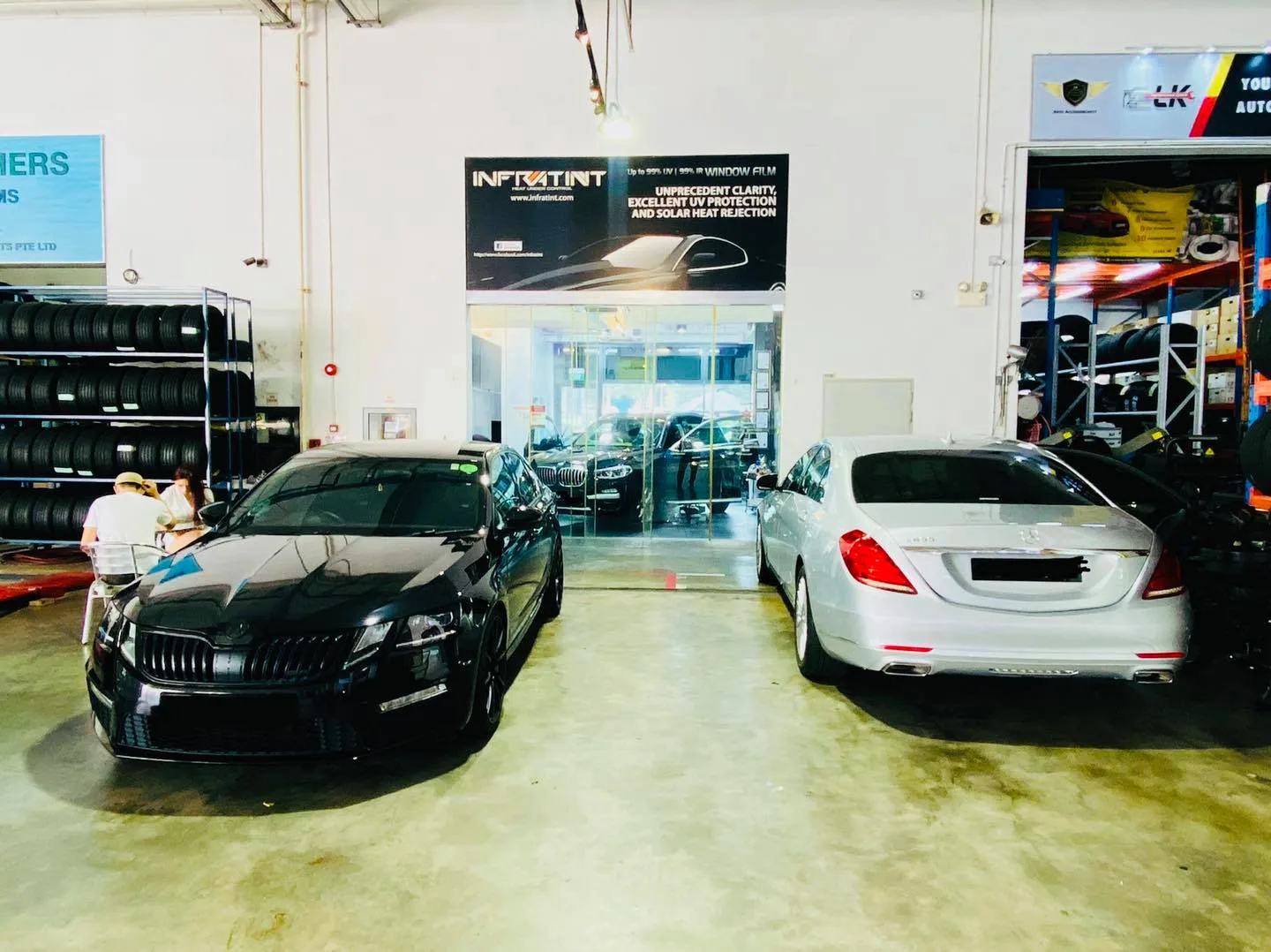 Black coupe and white Mercedes-Benz S-Class in the Infratint Singapore workshop