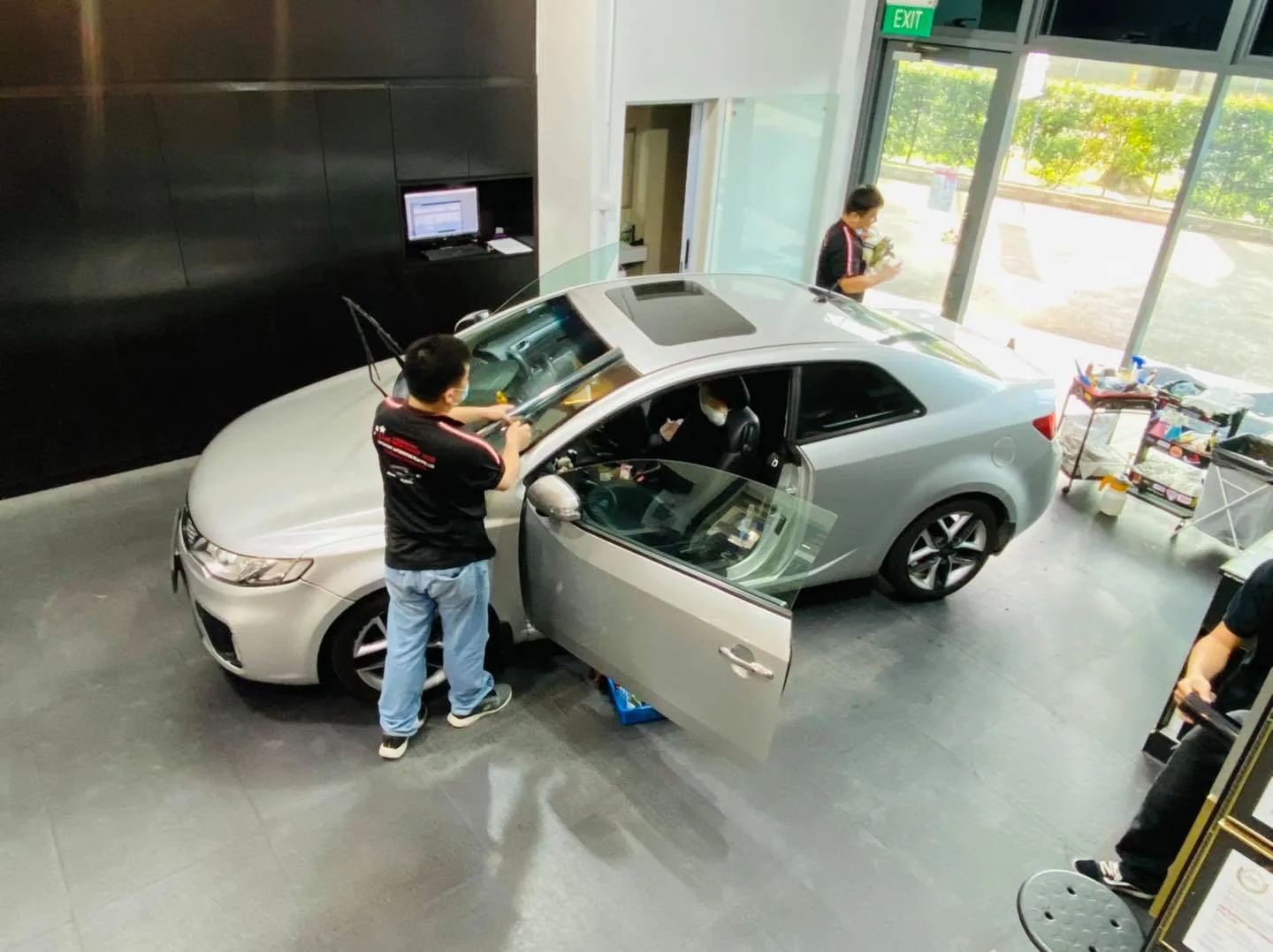 Overhead view of a silver Kia coupe being tinted at Infratint Singapore