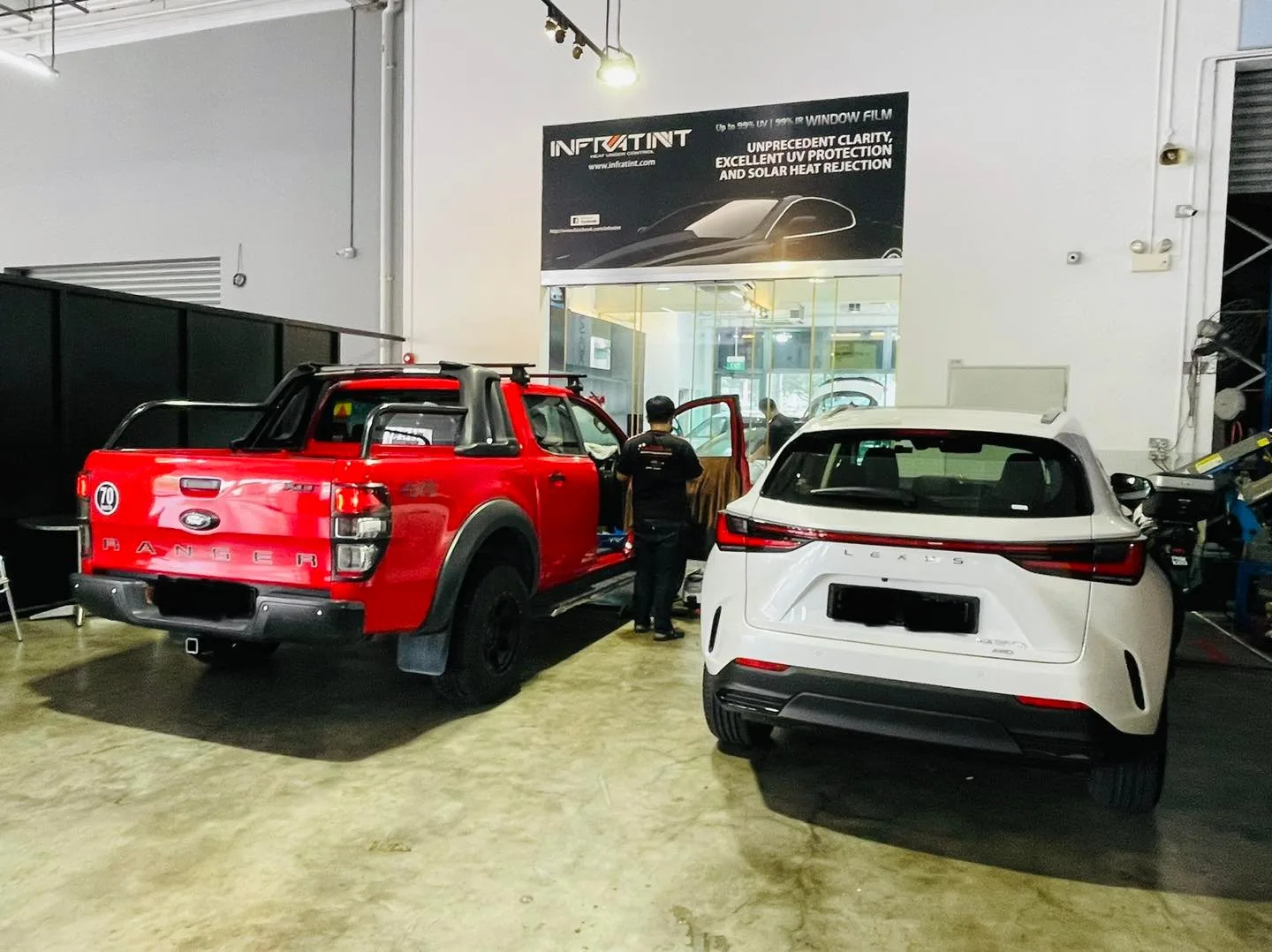 Red Ford Ranger pickup and a white Lexus SUV at Infratint Singapore for window tinting