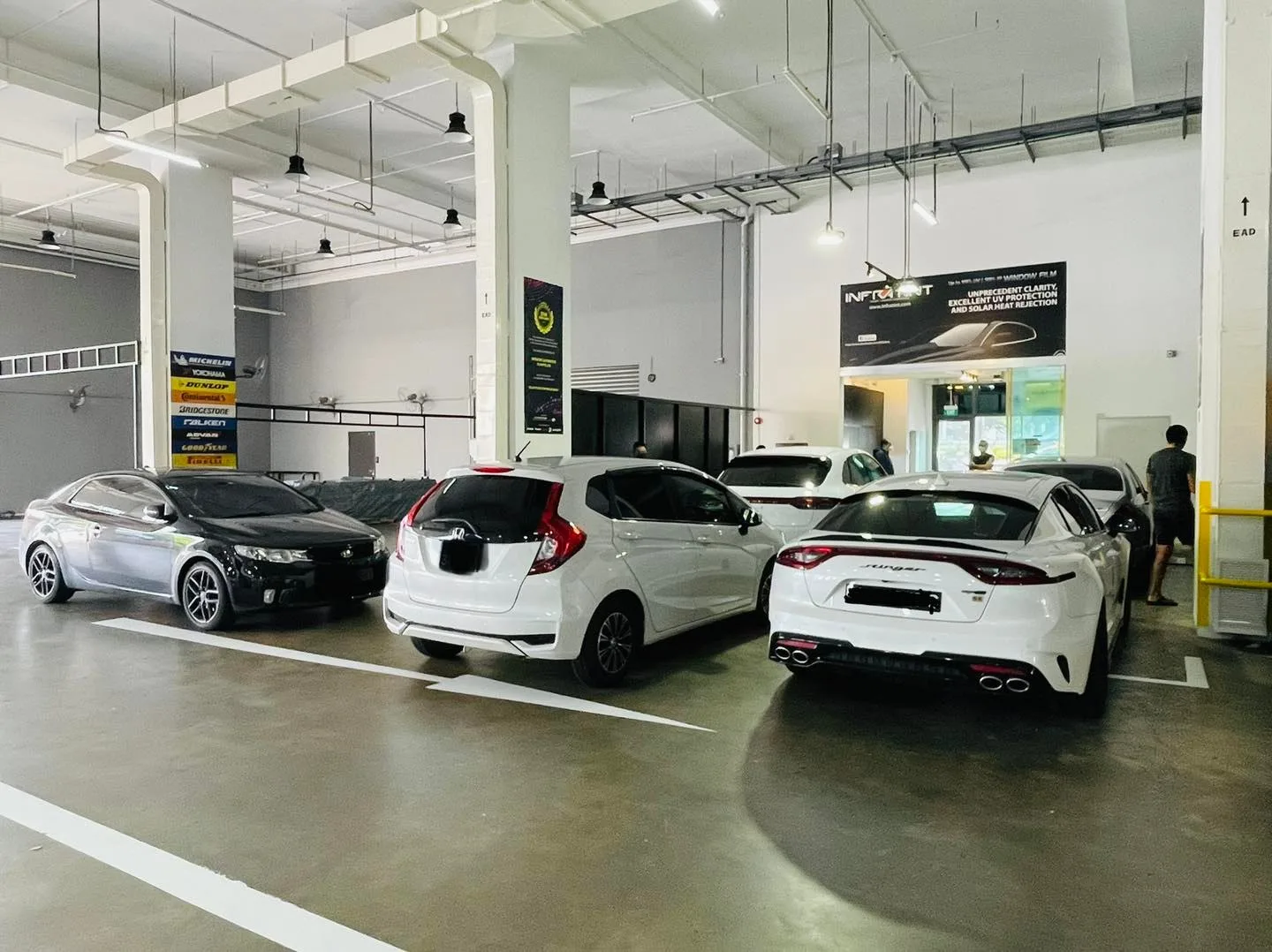 Silver Lexus, black sedan and a white Honda hatch parked in the Infratint Singapore workshop