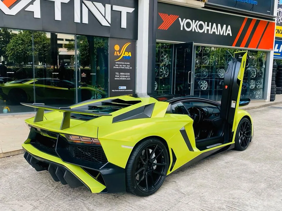 Rear view of a lime green Lamborghini Aventador with door raised at Infratint Singapore