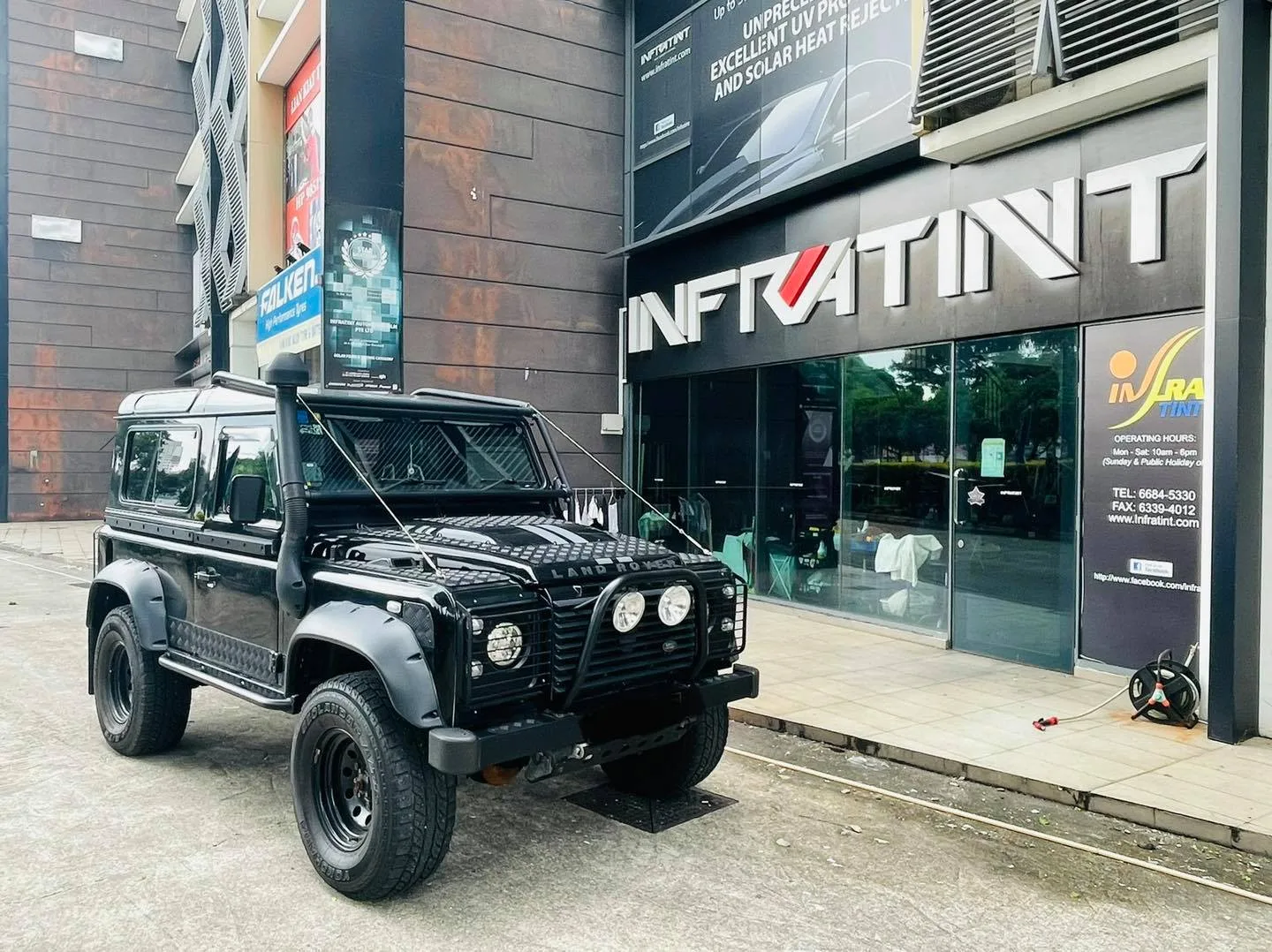 Black Land Rover Defender parked outside the Infratint Singapore shopfront