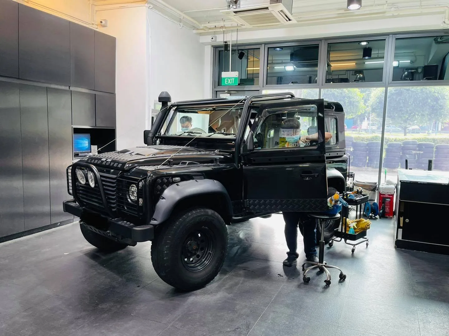 Installer tinting a black Land Rover Defender at Infratint Singapore