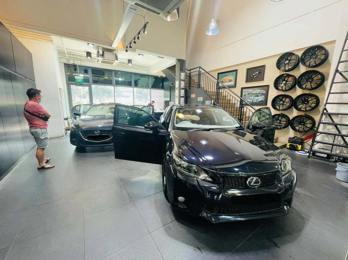 Black Lexus sedan and grey Mazda inside the Infratint Singapore showroom