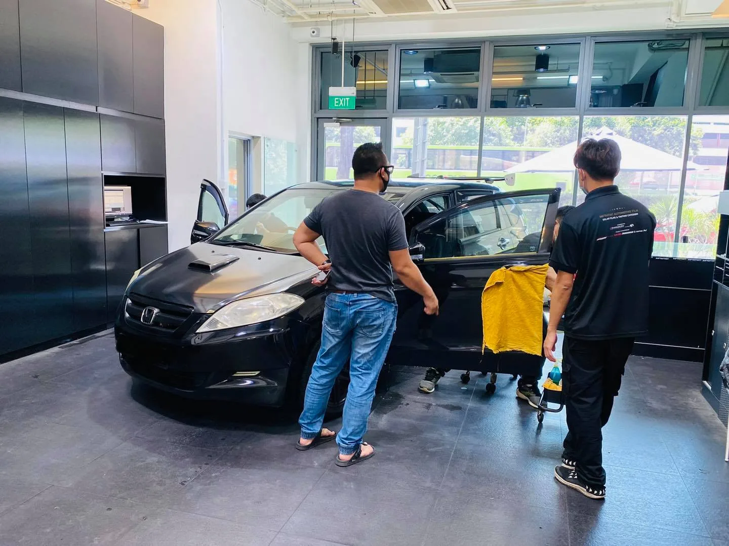 Tinters preparing a black Honda MPV for window film at Infratint Singapore