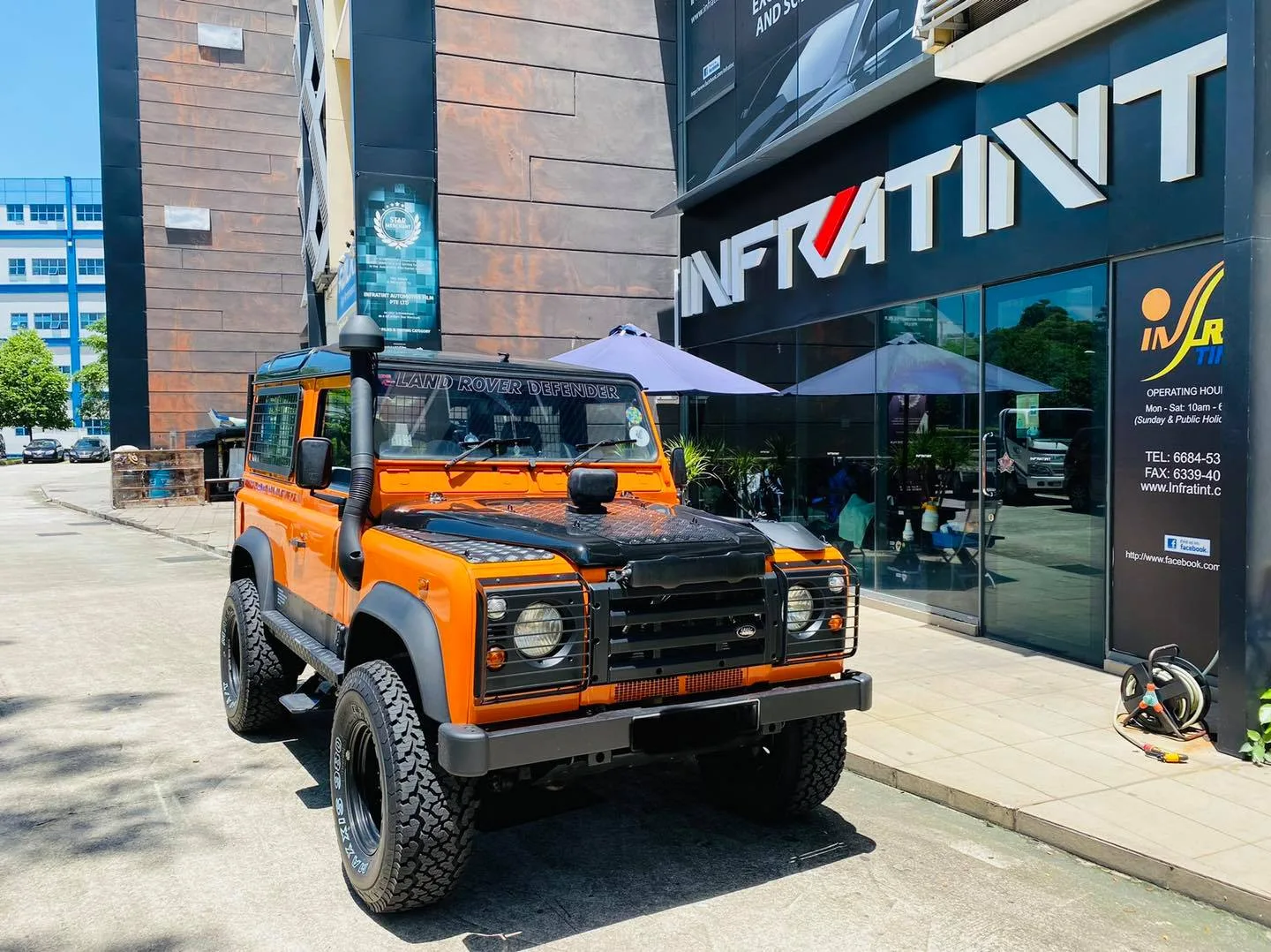 Finished orange Land Rover Defender parked outside the Infratint Singapore shopfront