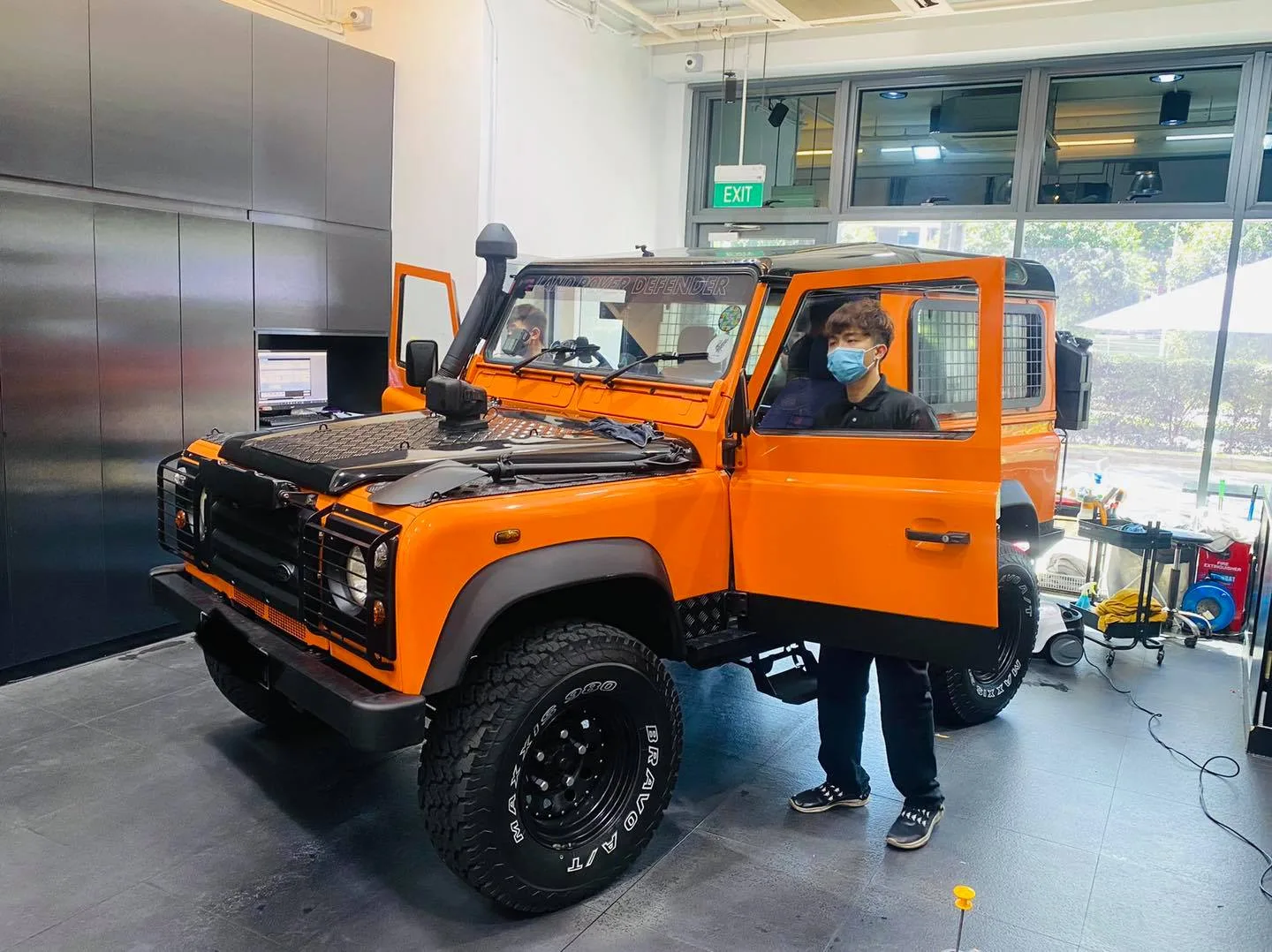 Orange Land Rover Defender with snorkel in front three-quarter view at Infratint Singapore