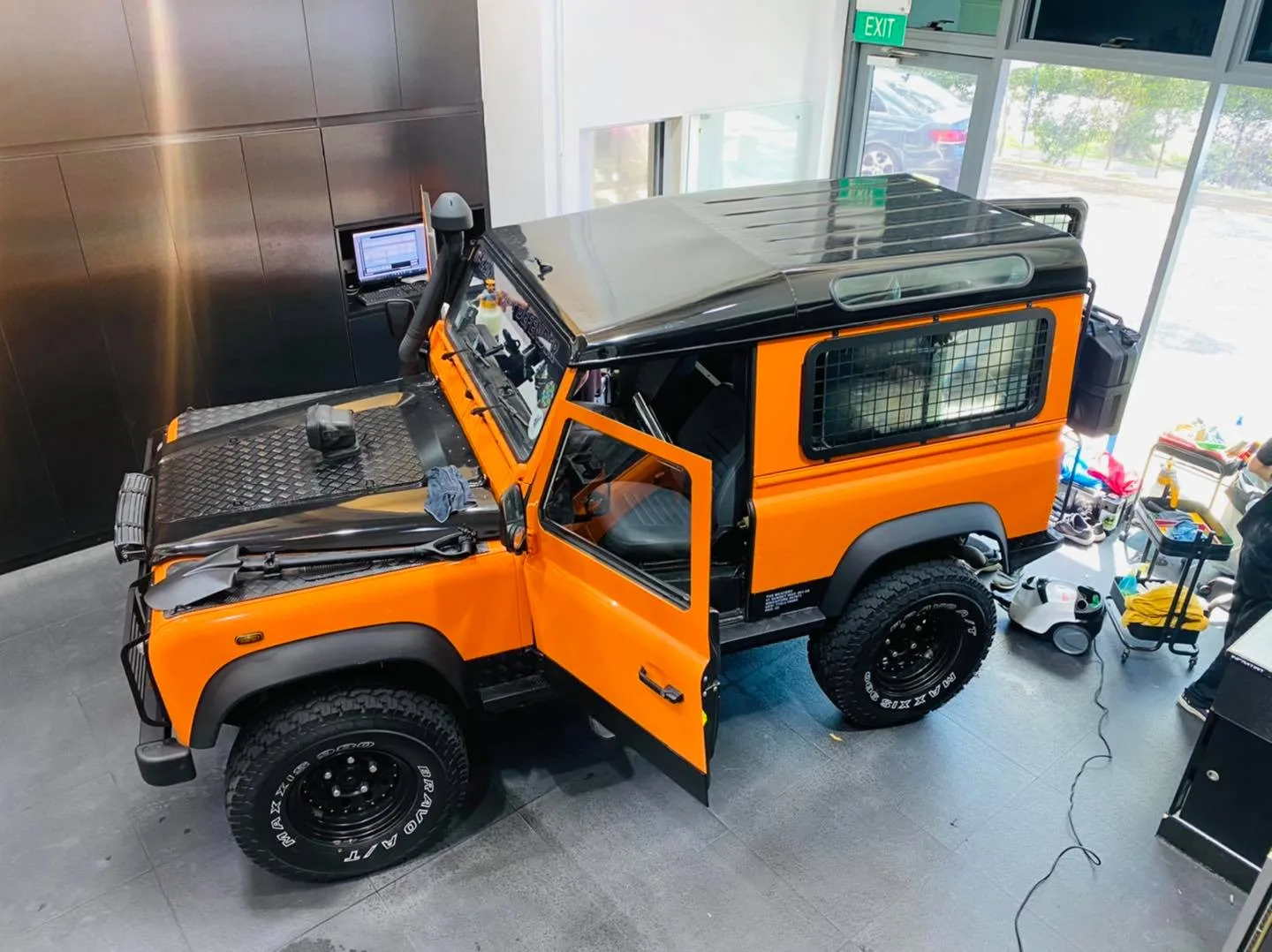 Overhead view of an orange Land Rover Defender during tinting at Infratint Singapore