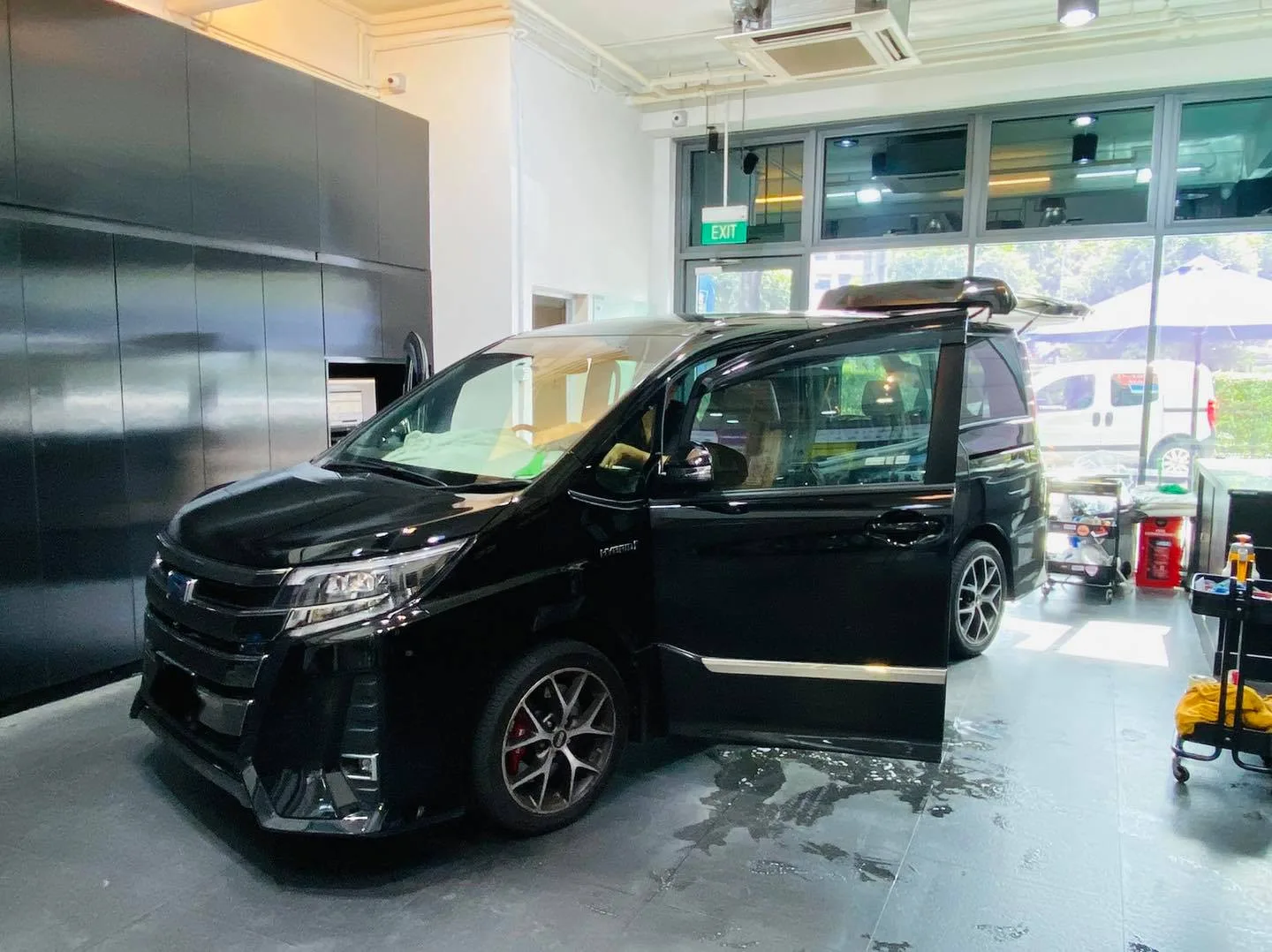 Black Toyota Noah at a front three-quarter angle in the Infratint Singapore install bay