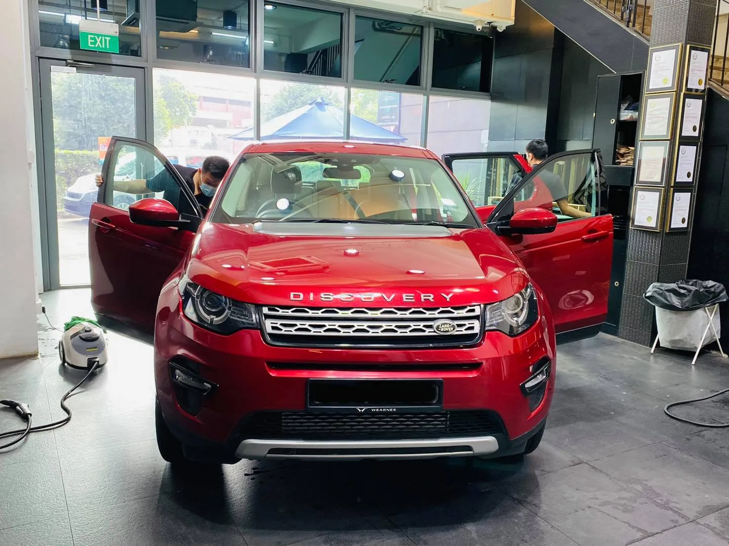 Red Land Rover Discovery with doors open during window tinting at Infratint Singapore
