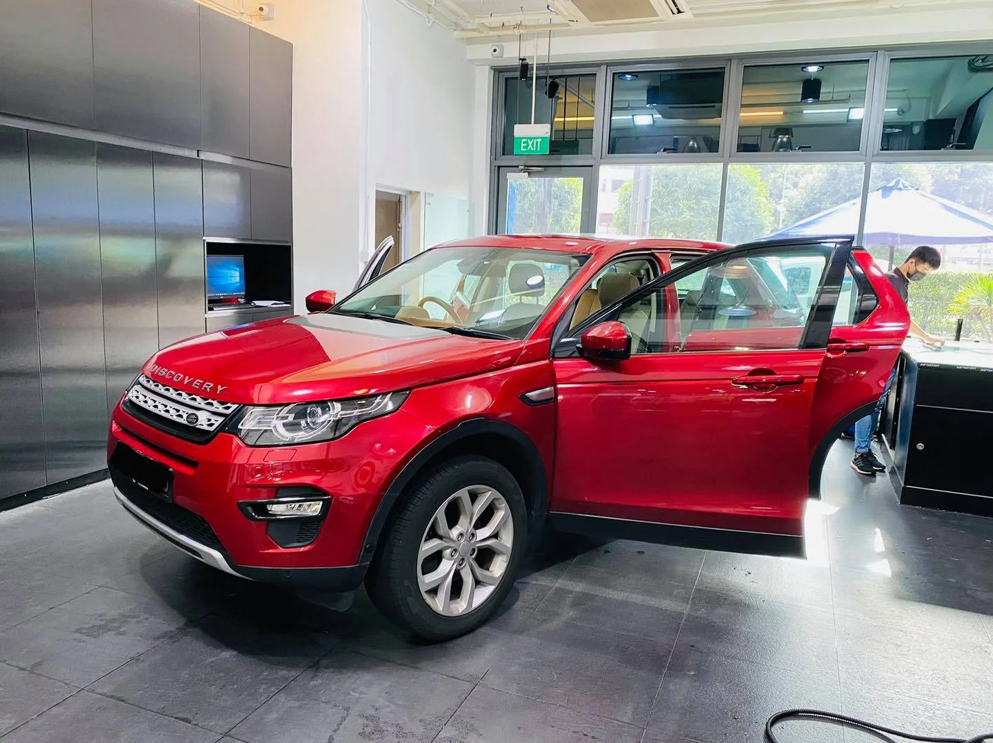 Red Land Rover Discovery at a front three-quarter view inside the Infratint Singapore showroom