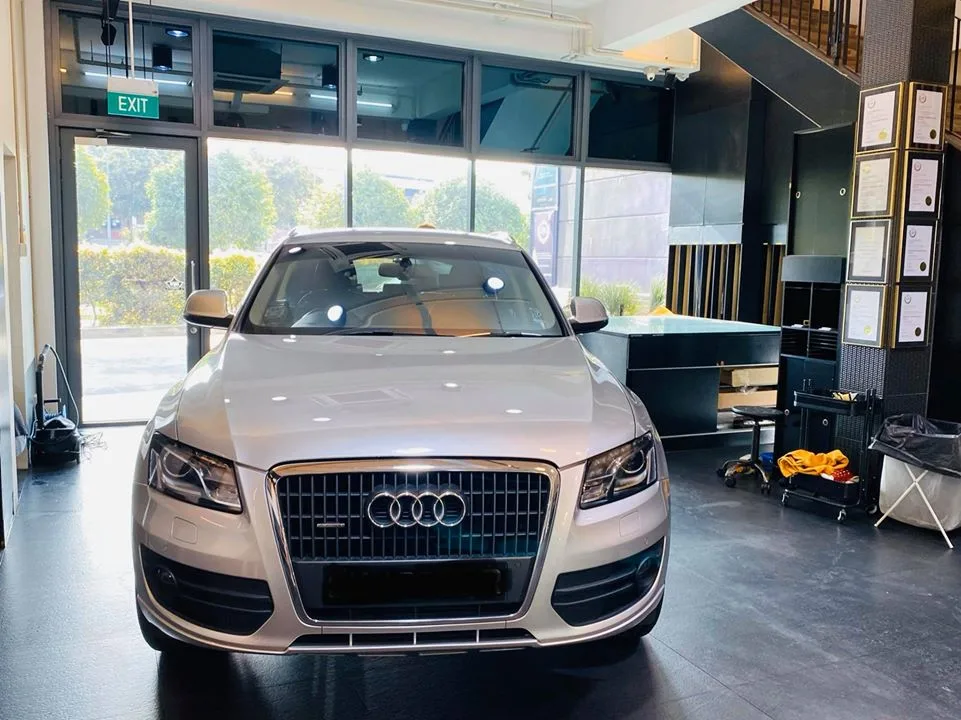 Front view of a silver Audi Q5 at Infratint Singapore with certificates on the wall