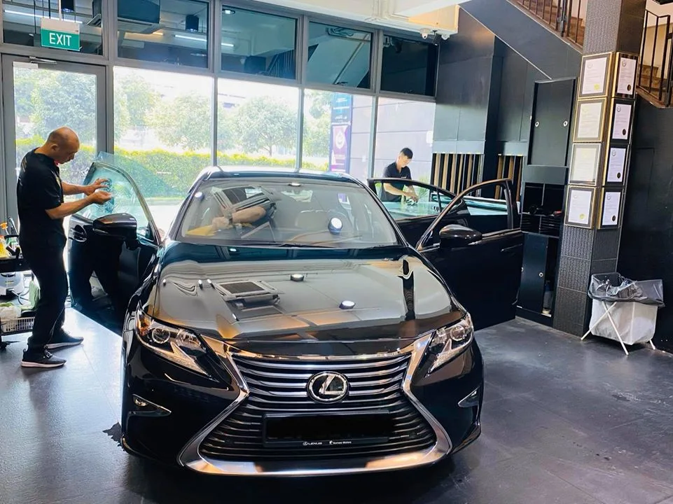 Black Lexus ES sedan with installers applying window film at Infratint Singapore