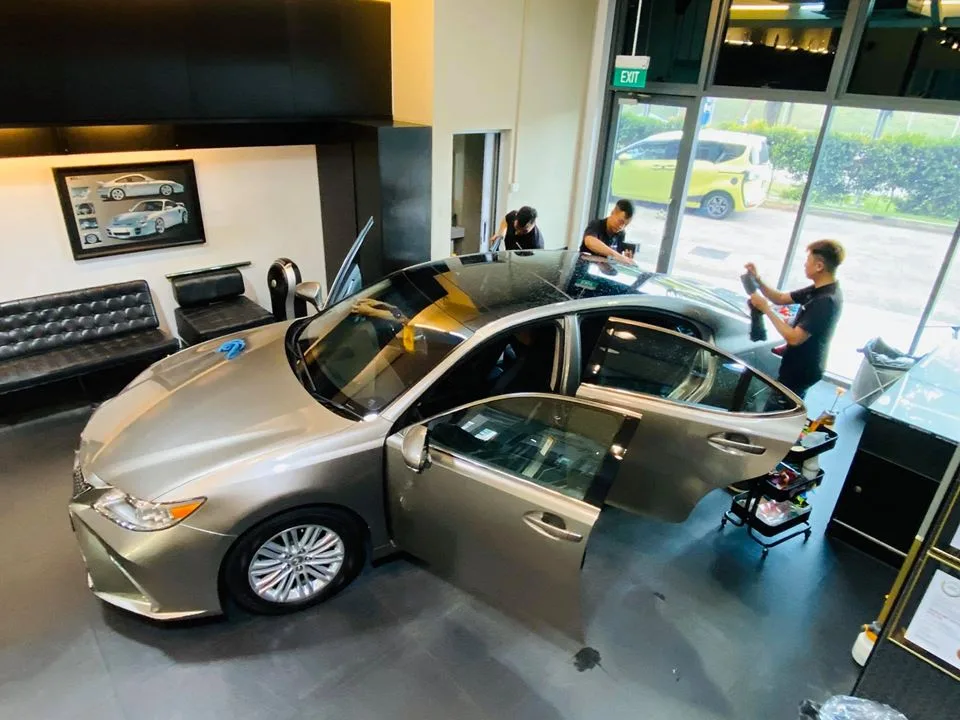 Overhead view of a champagne Lexus ES sedan being tinted by installers at Infratint Singapore