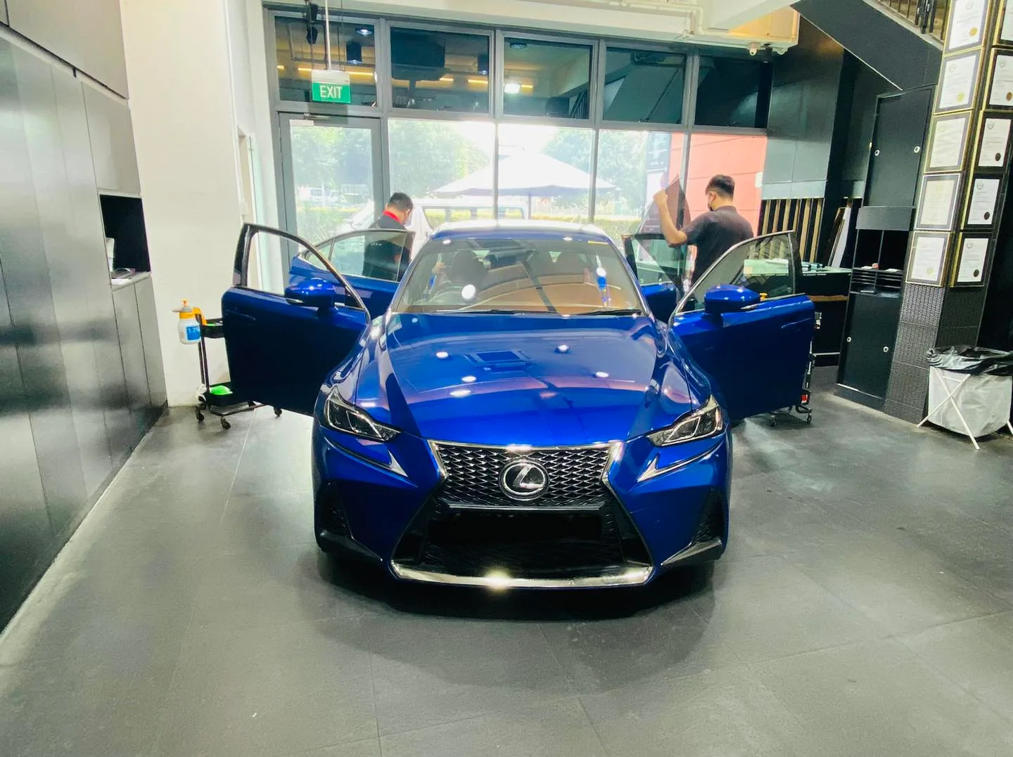 Blue Lexus IS sedan with doors open for window tinting at Infratint Singapore