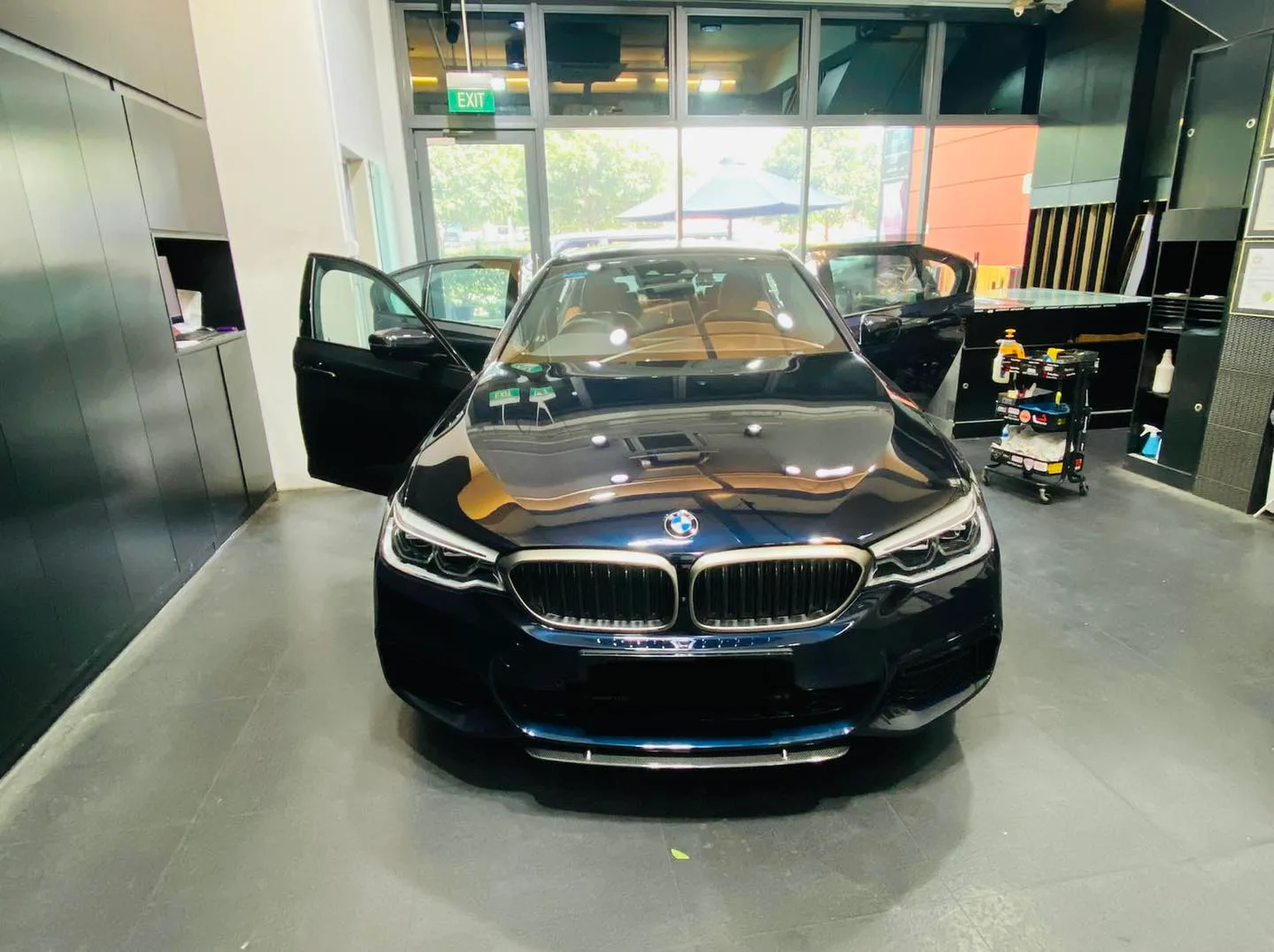 Dark blue BMW 5 Series with doors open for window tinting at Infratint Singapore