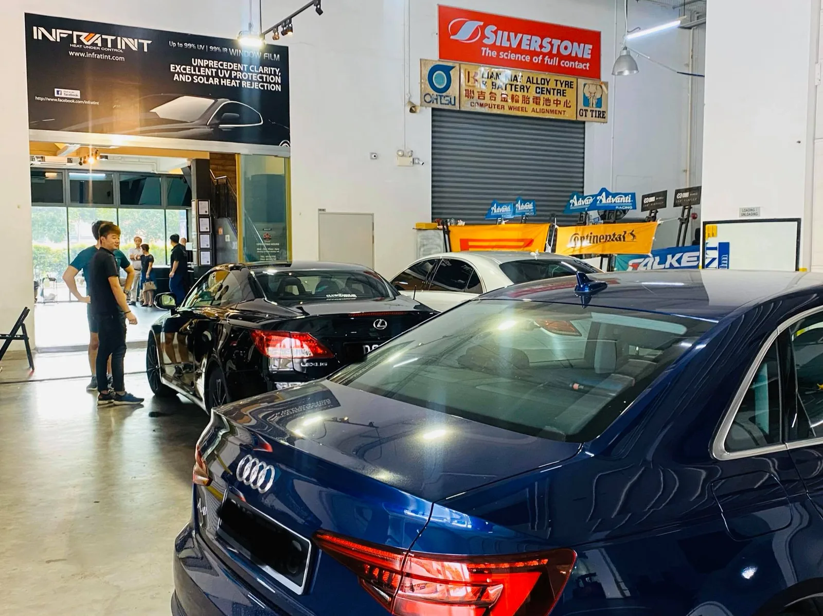 Blue Audi A4 and black Lexus sedan at Infratint Singapore for window tinting