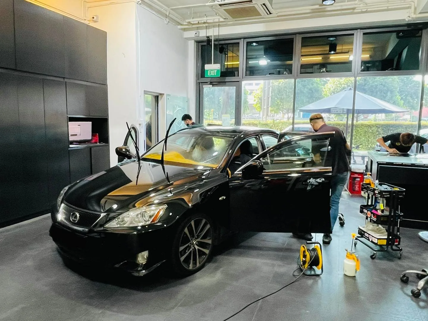 Black Lexus IS sedan during window film installation at Infratint Singapore