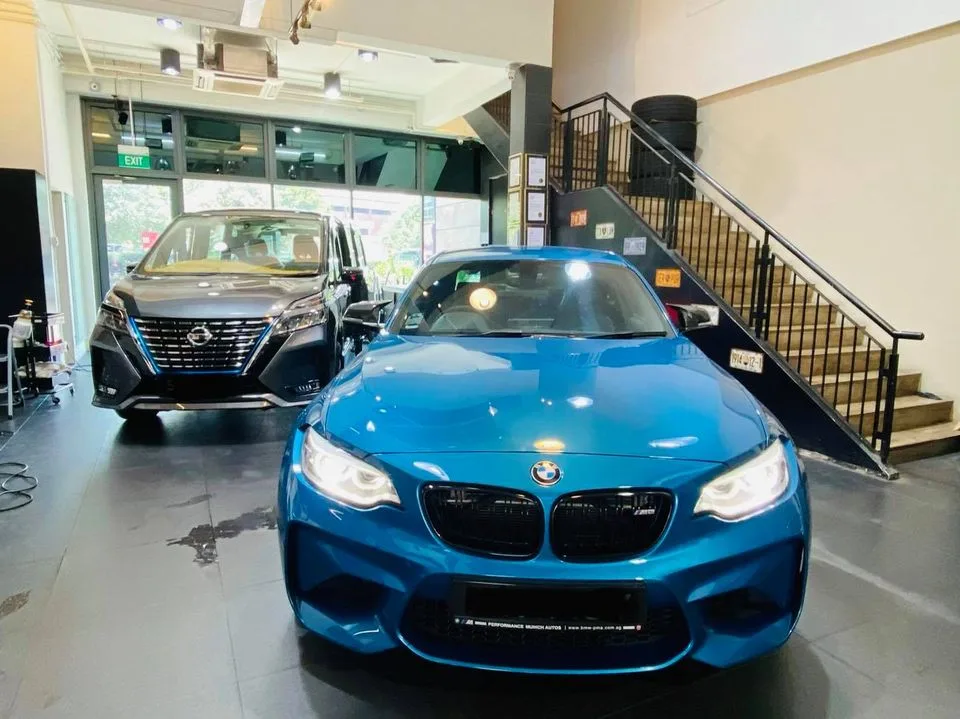 Blue BMW M2 coupe with a Nissan SUV inside Infratint Singapore