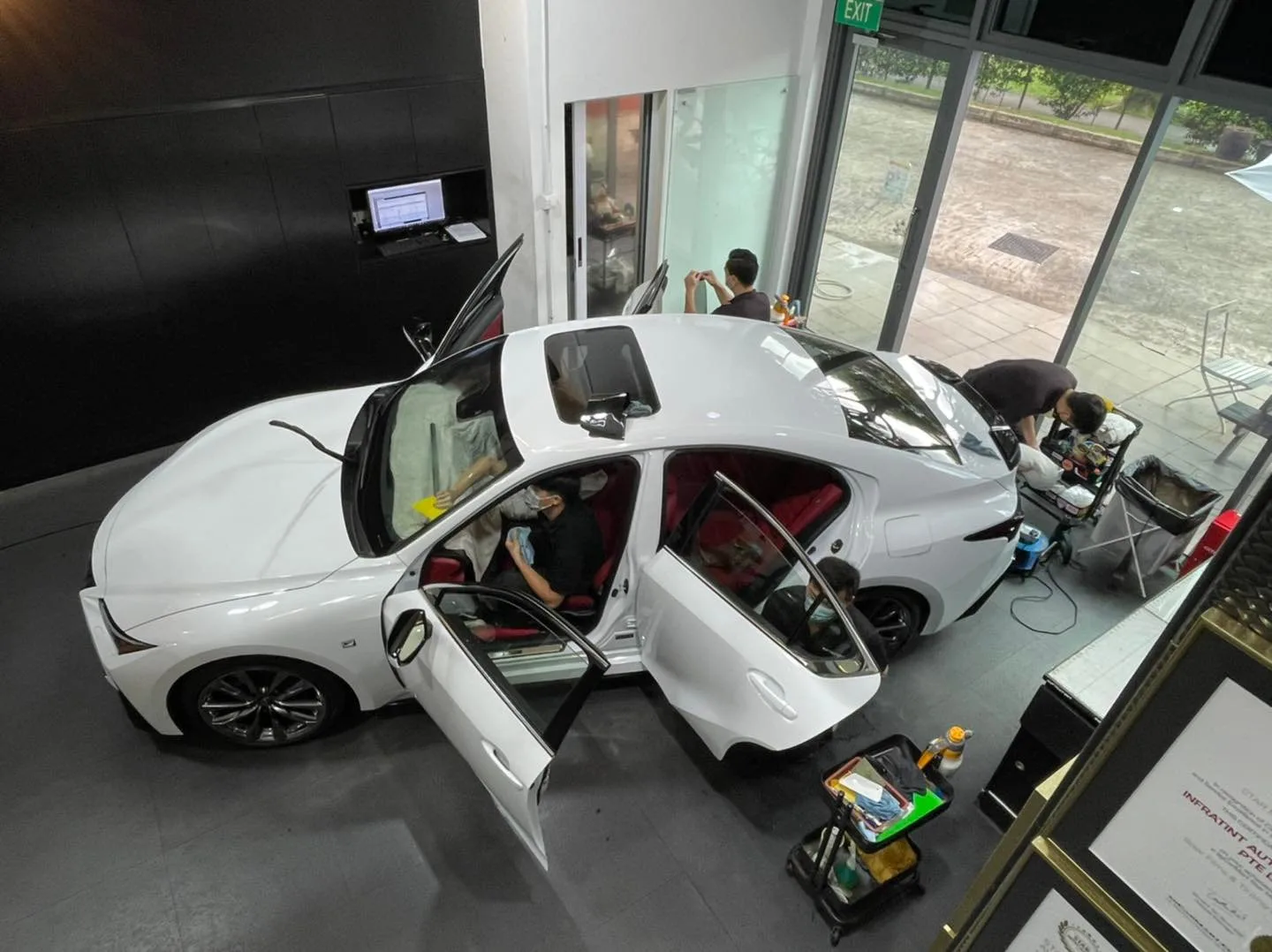 Overhead view of a white Lexus IS with red interior being tinted at Infratint Singapore