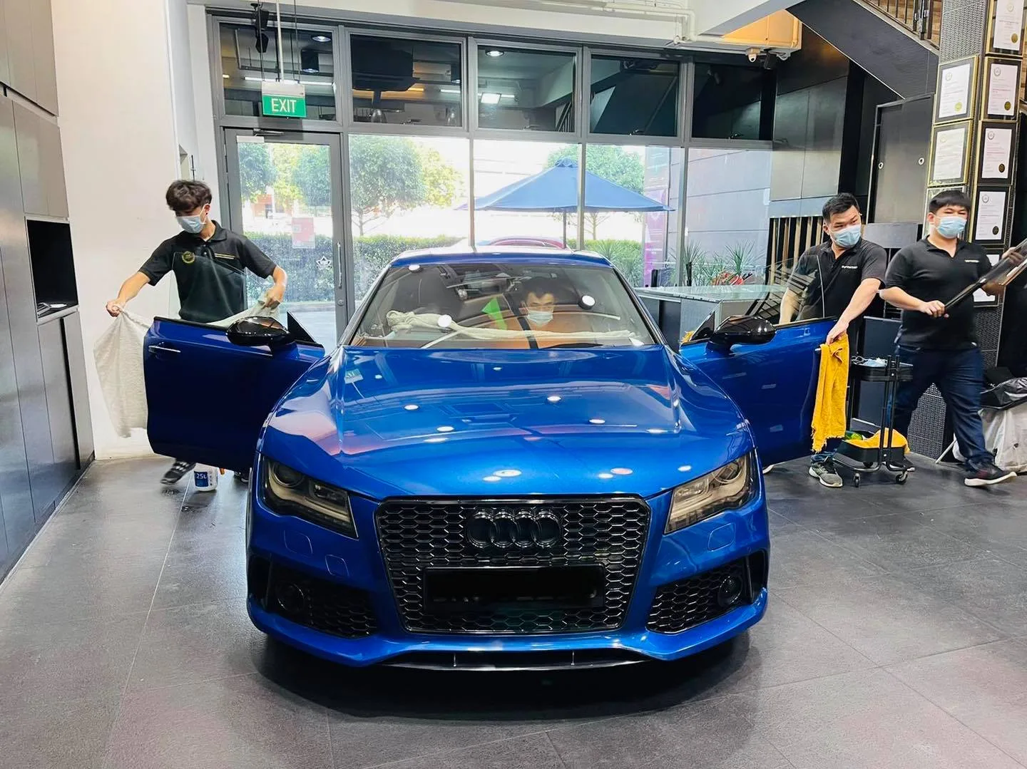 Blue Audi RS7 Sportback with tinters at work during window film installation at Infratint Singapore