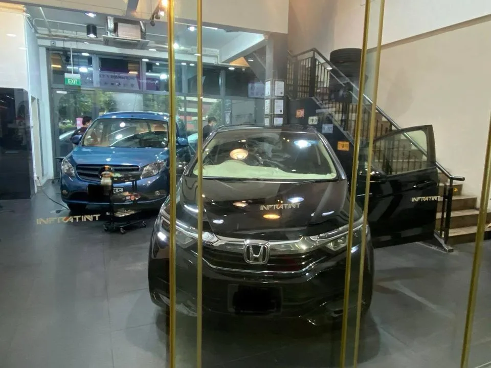 Black Honda sedan seen through the glass entrance at Infratint Singapore