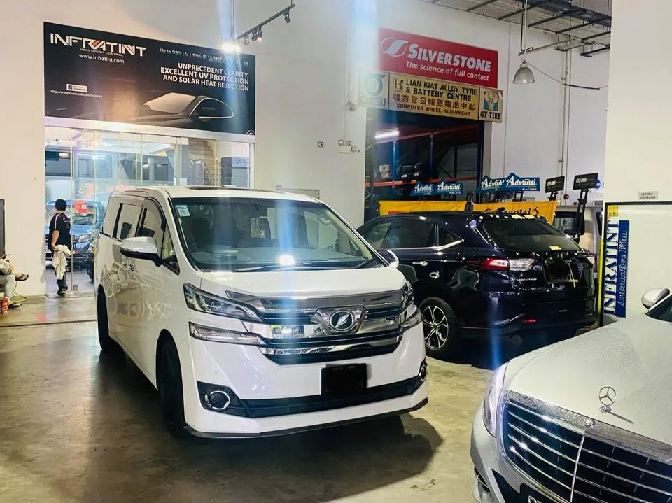 White Toyota Vellfire MPV among other cars at Infratint Singapore for window tinting