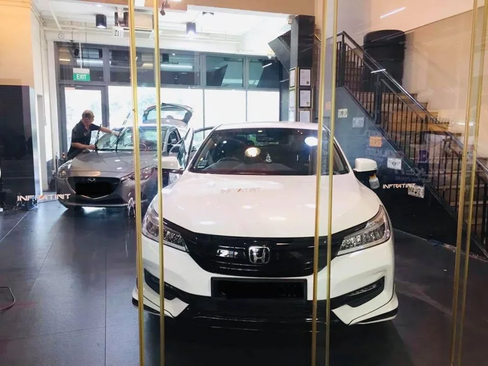 White Honda sedan with a silver Mazda being tinted behind it at Infratint Singapore