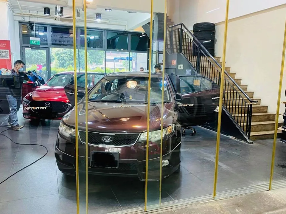 Brown Kia and red Mazda being window tinted inside Infratint Singapore