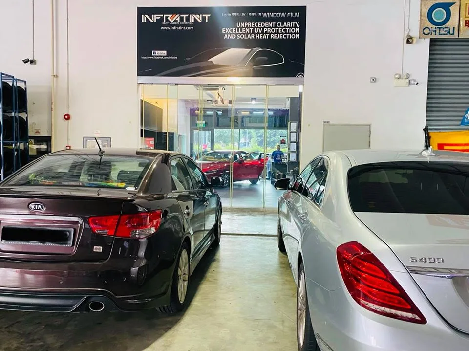 Brown Kia sedan and silver Mercedes-Benz S-Class waiting for tinting at Infratint Singapore