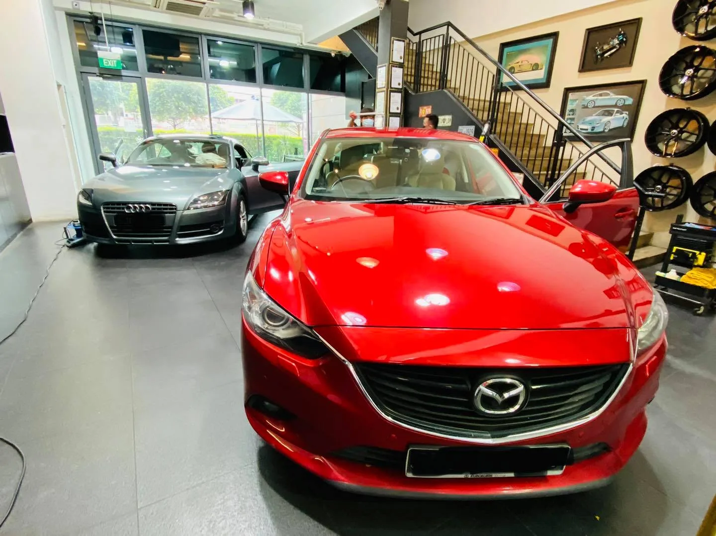 Red Mazda sedan and grey Audi TT inside the Infratint Singapore showroom for window tinting