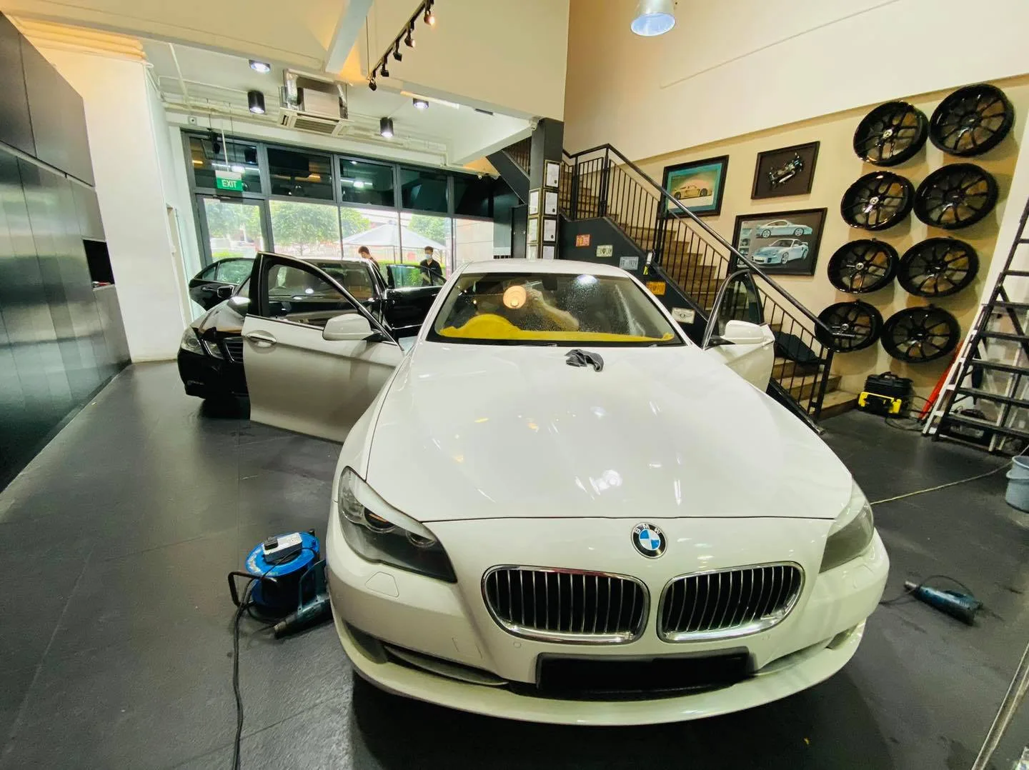 White BMW 5 Series with doors open during window tinting at Infratint Singapore