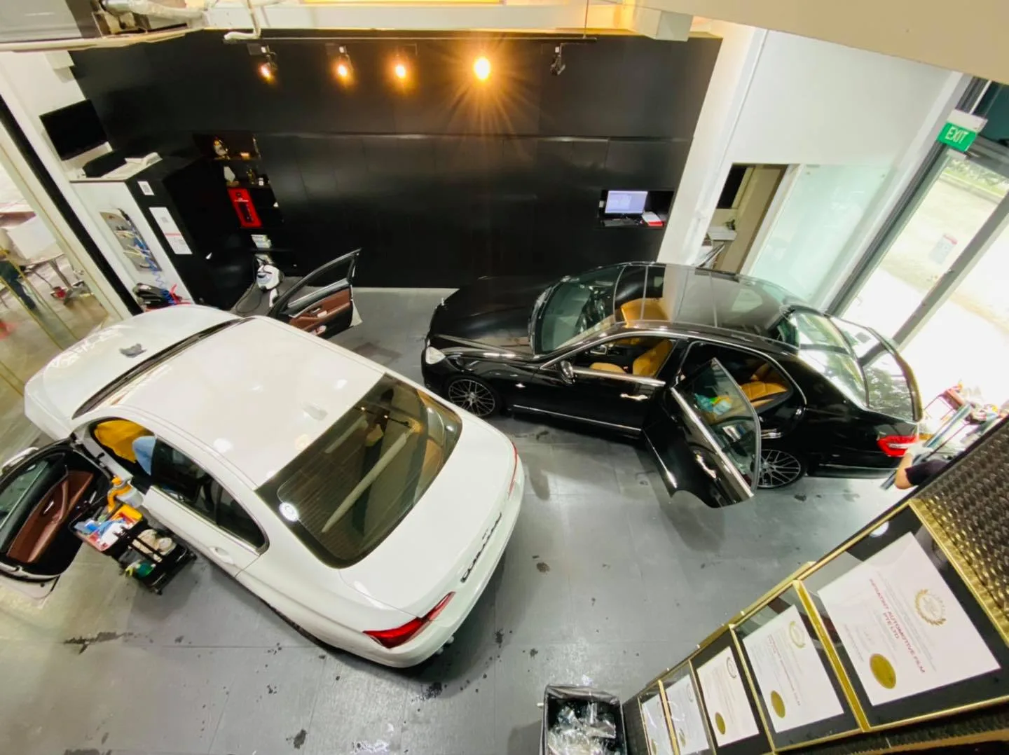 Overhead view of a white sedan and black Mercedes-Benz being tinted at Infratint Singapore