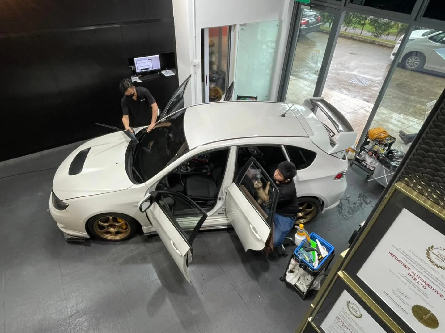 Overhead view of a white Subaru Impreza being tinted at Infratint Singapore