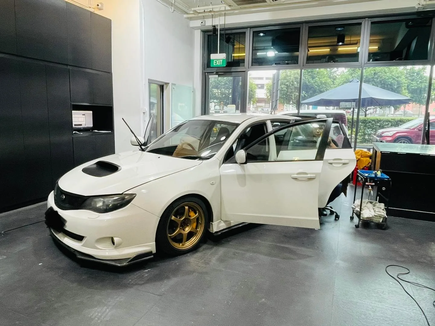 Side profile of a white Subaru Impreza on gold wheels at Infratint Singapore