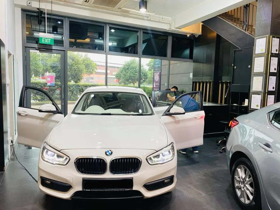 White BMW 1 Series and a grey hatchback during window tinting at Infratint Singapore